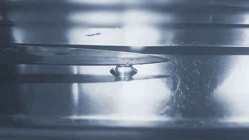 Knife touching water drop on table