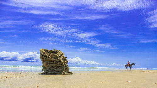 People at beach against blue sky