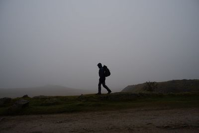 Man photographing on field against sky