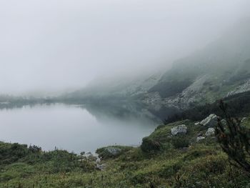 Scenic view of lake by mountains against sky