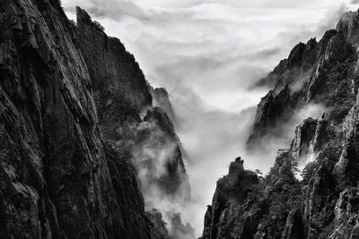 Scenic view of rocky mountains against cloudy sky