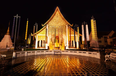 Illuminated temple building against sky at night