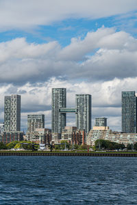 Sea by buildings against sky in city