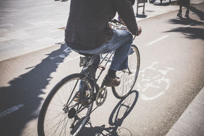 Low section of man with bicycle on road