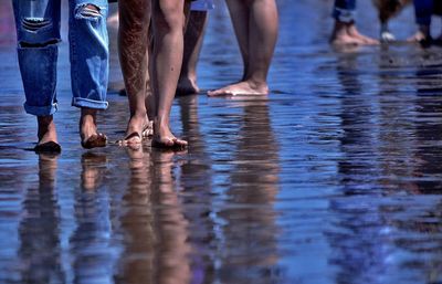 Low section of people standing on beach