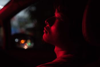 Light falling on thoughtful man sitting in car