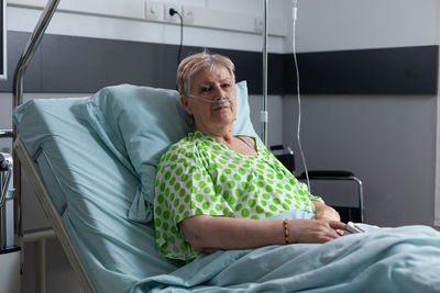 High angle view of young woman sitting on bed at home