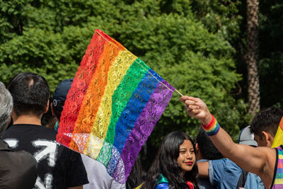 Rear view of people holding multi colored umbrellas