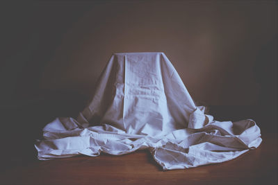 Close-up of white paper on table against black background