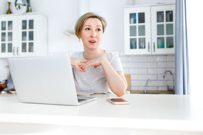 Portrait of mid adult woman using smart phone at home