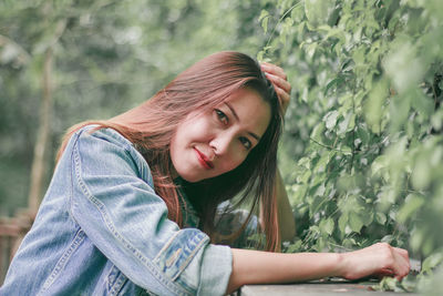 Side view portrait of beautiful woman by plants