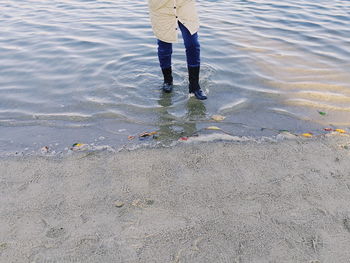 Low section of man standing in water