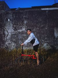 Portrait of man riding bicycle on field