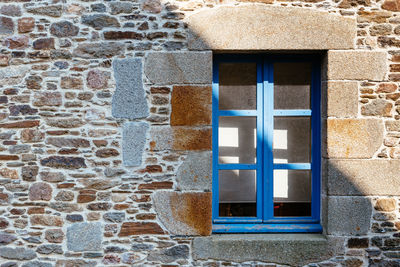 Blue window on stone wall