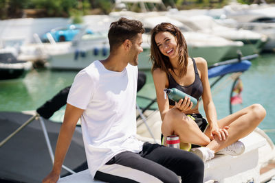 Smiling couple while sitting at harbor