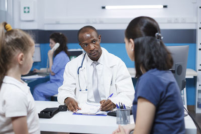 Female doctor examining patient in office