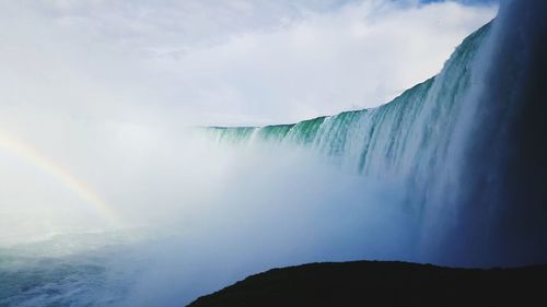 Low angle view of waterfall against sky