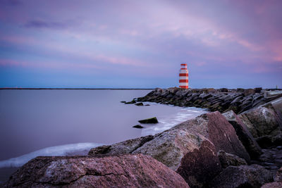 Rocks by sea against sky