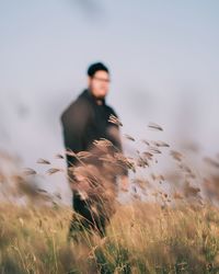 Man standing on field against sky