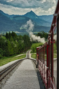 Train amidst mountains against sky