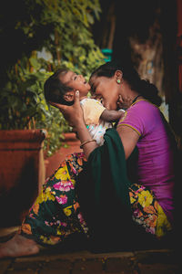 Mother and daughter sitting outdoors