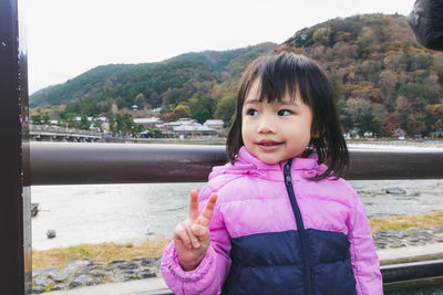 Portrait of smiling girl standing on riverbank