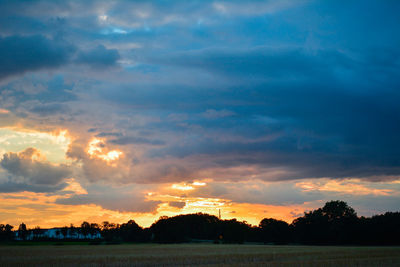 Scenic view of dramatic sky over silhouette landscape