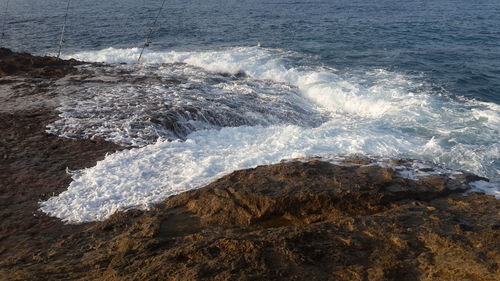 High angle view of waves splashing on rocks