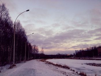 Snow covered road against sky during winter