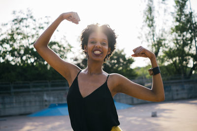 Portrait of smiling young woman standing in park