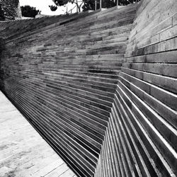 High angle view of wooden bench on footpath