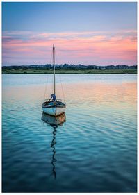 Sailboat in sea against sky during sunset