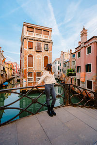 Woman on bridge with characteristic venetian building behind her