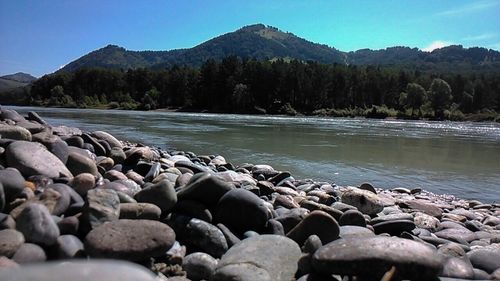 Rocks in lake against sky