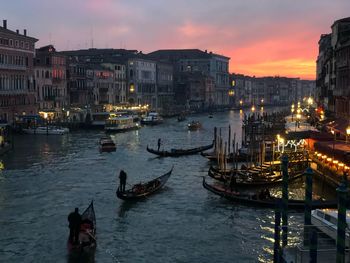 Boats moored in sea against sky at sunset