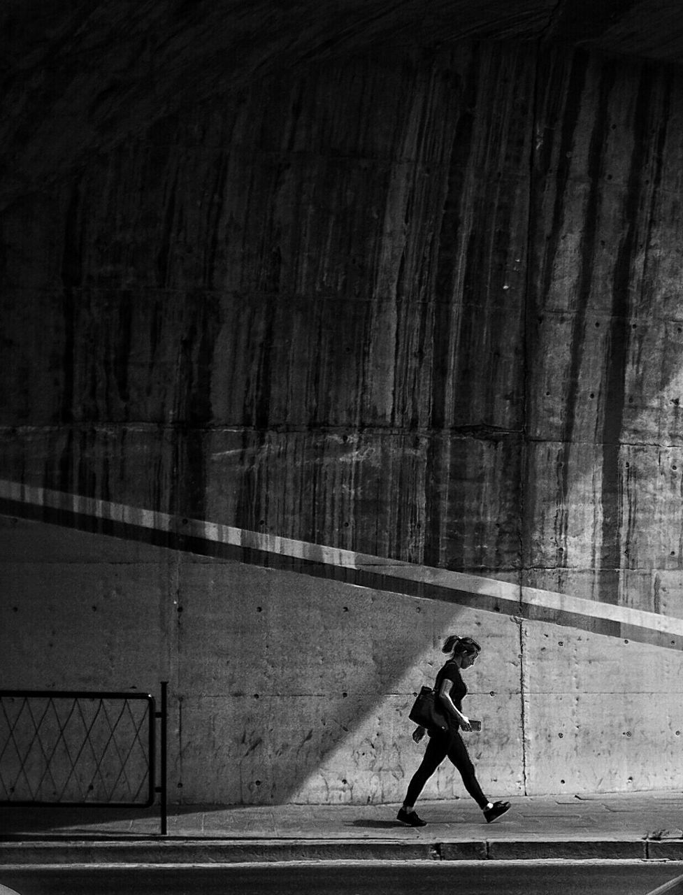 full length, lifestyles, leisure activity, walking, built structure, men, architecture, standing, casual clothing, rear view, side view, building exterior, person, shadow, wall - building feature, street, day, sunlight