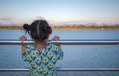 Rear view of woman looking at sea against sky