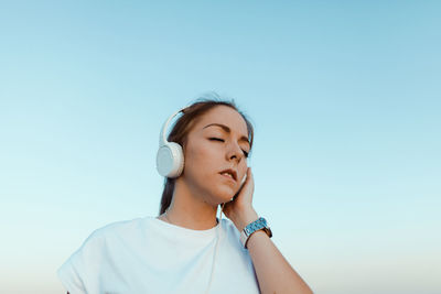 Portrait of a beautiful young woman against blue sky