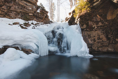 Frozen waterfall under snow cover in wisla czarne - rodla cascades in the polish beskydy, poland.