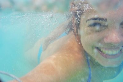 Close-up portrait of young woman swimming in pool