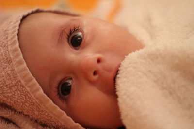 Portrait of cute baby lying on bed