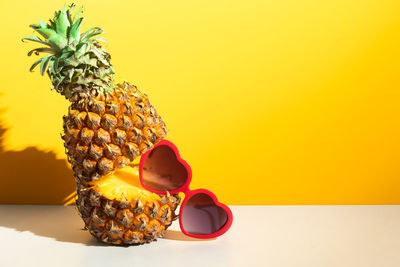 Close-up of stuffed toy over table against yellow background