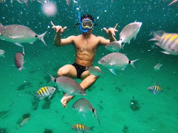 Man snorkeling amidst fishes in sea