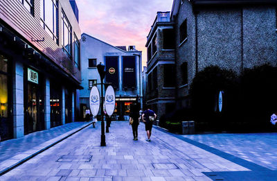 People on street in city against sky