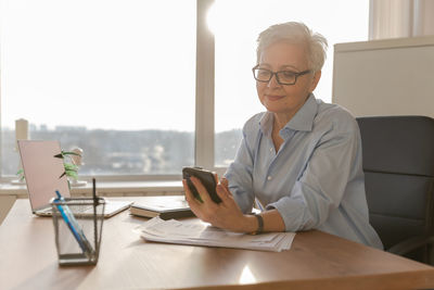 Portrait of young woman using laptop at table