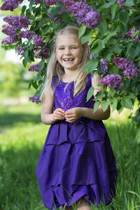 Portrait of young woman standing by plants