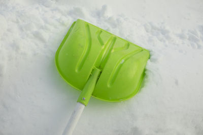 Shovel for snow. green shovel for clearing path from snow. gardener's equipment.