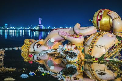 Close-up of illuminated statue against sky at night