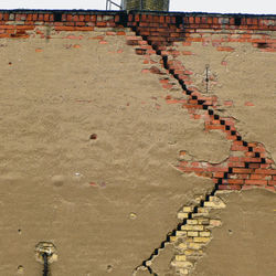 Low angle view of broken brick wall