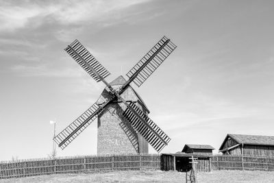 Traditional windmill on field against sky